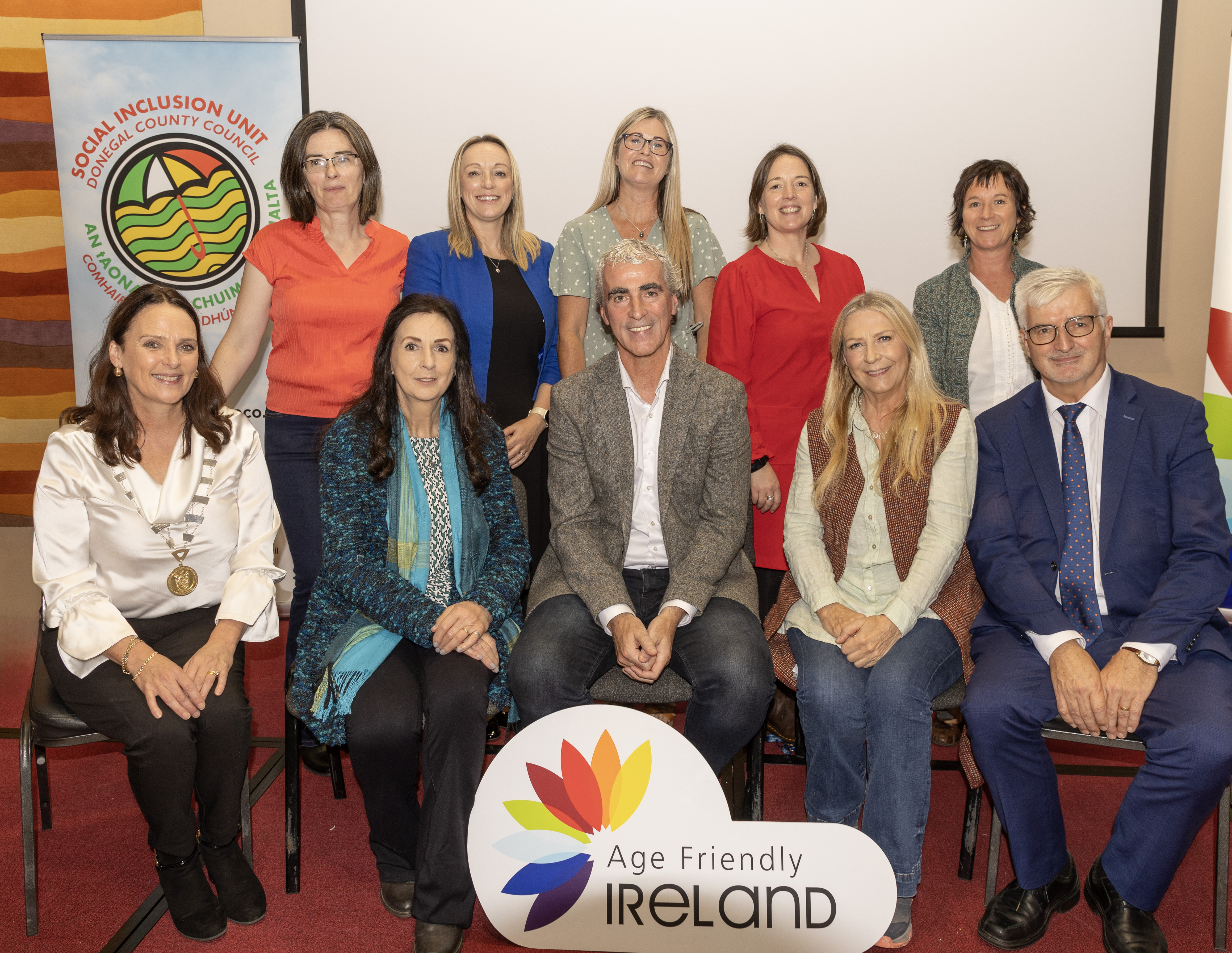 Seated left to right - Cathaoirleach Cllr Niamh Kennedy, Moya Brennan Age Friendly Ambassador, Jim Mc Guinness, Mairead Ní Mhaonaigh, John G. McLaughlin Chair of Age Friendly Alliance, Standing left to right - Mairead Lynch Community Development, Rosita Mahony Age Friendly Programme Manager Donegal, Mairead Cranley Regional Manager for Age Friendly Ireland, Clodagh Murray Healthy Homes Co-ordinator & Trudi O’Reilly Technical Advisor, Donegal County Council